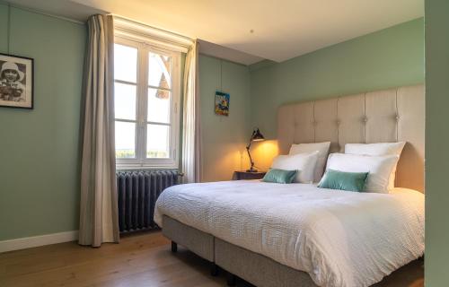une chambre avec un grand lit et une fenêtre dans l'établissement New Cottage & spa de nage Guesthouse, à Honfleur