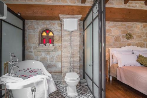 a bathroom with a bath tub and a bed at Villa Galanoussa in Zakynthos
