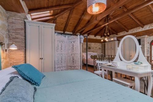 a bedroom with a bed and a mirror and a table at Villa Galanoussa in Zakynthos