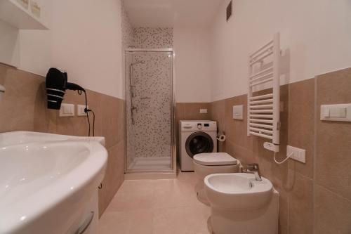 a bathroom with a sink and a washing machine at The Arc Residence in Astana