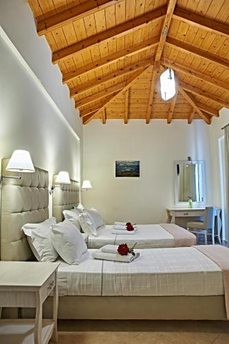 a bedroom with two beds and a wooden ceiling at Element Hotel in Elafonisos