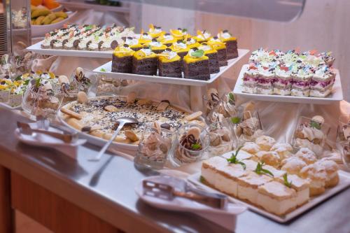 a buffet filled with different types of cakes and pastries at Mediteran Hotel & Resort in Budva