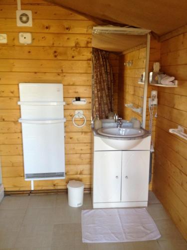 - une salle de bains avec lavabo dans une chambre en bois dans l'établissement Le Bois Faé, à La Bastide