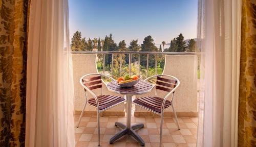 a table with a bowl of fruit on a balcony at Mediteran Hotel & Resort in Budva