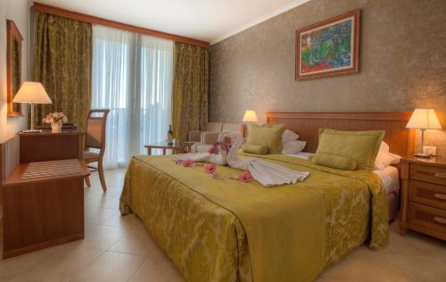 a hotel room with a bed with two dolls on it at Mediteran Hotel & Resort in Budva