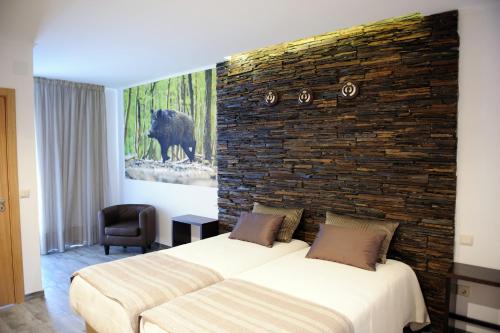 um quarto com 2 camas e uma parede de tijolos em Casa da Eira em Cadaval