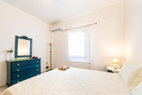 a bedroom with a bed and a mirror and a dresser at Amazing Sea View Villa in Parikia
