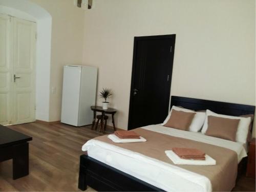 a bedroom with a large bed and a black cabinet at Gulo's Home in Tbilisi City