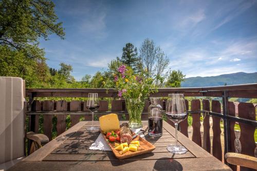 a table with a plate of food and wine glasses at Tourist Farm Kranjc in Kobarid