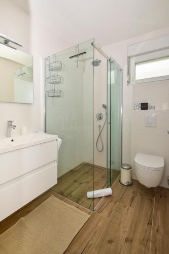 a bathroom with a glass shower and a toilet at Apartments Evelin in Makarska