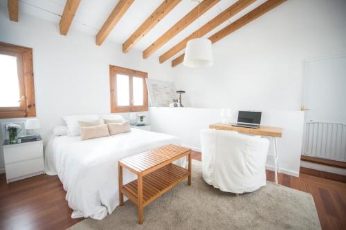 een witte slaapkamer met een bed en een tafel bij Casa en el barrio de Santa Catalina - Palma Aire Acondicionado de 2023 in Palma de Mallorca