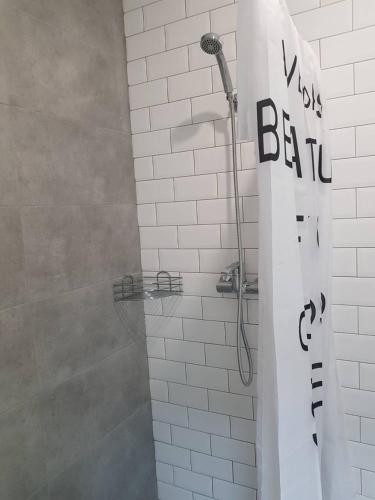 a bathroom with a shower with a white tiled wall at Hostel City Center in Chişinău