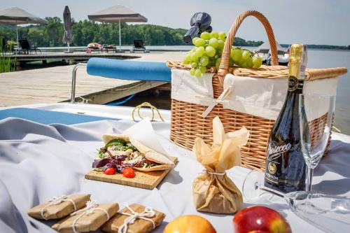 a table with a basket of fruit and a bottle of wine at Hotel Marina Club in Olsztyn