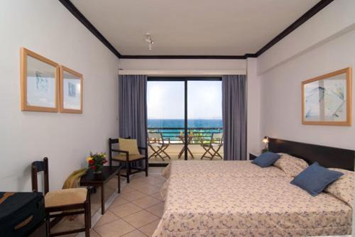 a bedroom with a bed and a balcony at Limira Mare Hotel in Neapolis