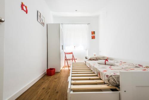 a bedroom with a bed and a chair in it at El Coral Apartment Valencia in Valencia