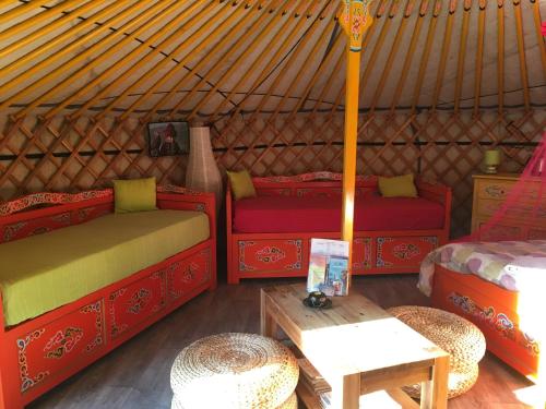 um quarto com duas camas e uma mesa numa tenda em Le Bois Faé em La Bastide