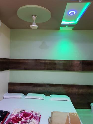 a bed in a room with a green ceiling at Hotel Shri Radhe Krishna in Godarpura