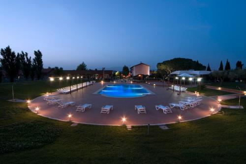 una gran piscina con tumbonas alrededor por la noche en Il Casale Corte Rossa, en Latina
