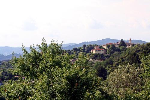 a village on top of a hill with trees at La Quercia Agriturismo in Imperia