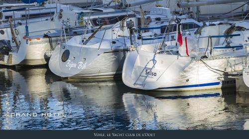 a group of boats are docked in the water at Grand Hôtel Bénodet Abbatiale Riviera Bretonne in Bénodet
