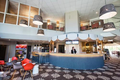 a man standing at a bar in a restaurant at Ibis Château-Thierry in Essômes-sur-Marne