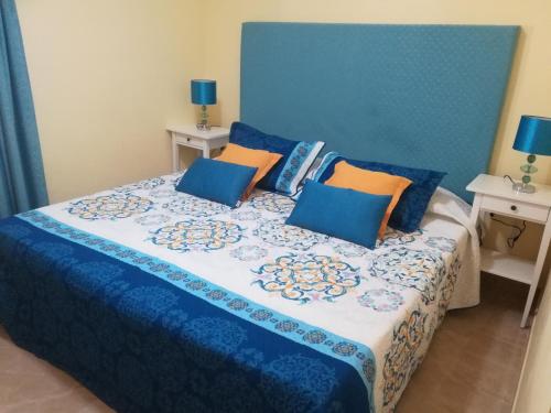 プラヤ・デル・イングレスにあるLas Olas Marのベッドルーム1室(青とオレンジの枕が備わるベッド1台付)