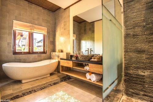 a bathroom with a tub and a sink at Bliss Ubud Abangan in Ubud