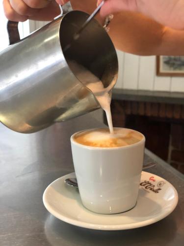 a person pouring coffee into a cup on a table at Hotel Sant Jordi in Segur de Calafell