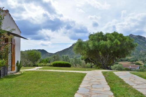 a path leading to a house with mountains in the background at Sa Rezzetta in Golfo Aranci