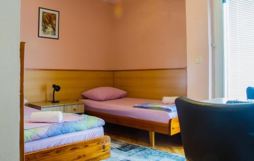 2 łóżka w pokoju z różowymi ścianami w obiekcie Motel Han w mieście Mostar