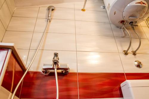 une douche avec un tuyau fixé au plafond dans l'établissement Motel Han, à Mostar