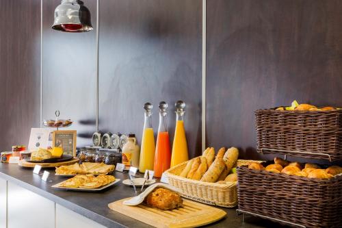 a buffet with bread and baskets of food on a counter at Best Western Park Hotel Geneve-Thoiry in Thoiry