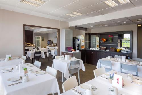 a dining room with white tables and white chairs at Best Western Park Hotel Geneve-Thoiry in Thoiry
