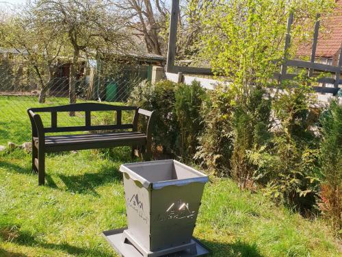 a trash can next to a bench in a yard at Waldstübchen in Kratzeburg