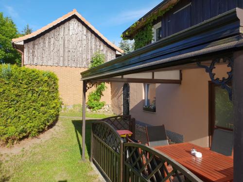 a patio with a wooden table and a roof at Waldstübchen in Kratzeburg