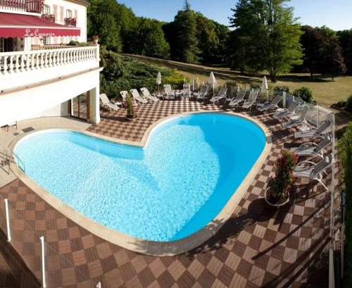 - une vue sur une piscine avec des chaises et un bâtiment dans l'établissement Le Château de la Tour, à Gouvieux