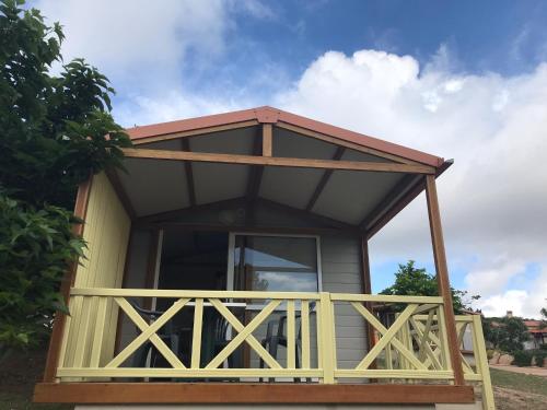 a tiny house with a porch and a roof at Camping Trinité in Bonifacio