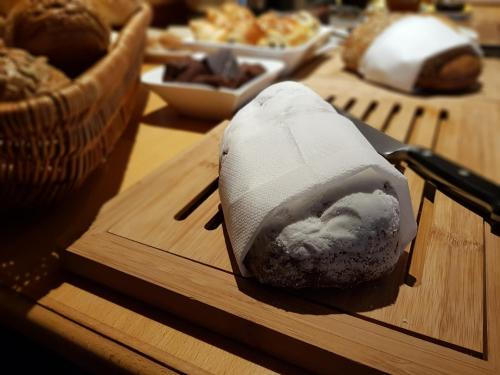 a block of sushi on a cutting board with a knife at Hotel Sonne in Seiffen