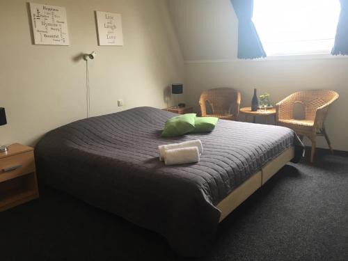 een slaapkamer met een groot bed met 2 groene kussens bij Hotel Eetcafé 't Dûke Lûk in Veenwoudsterwal