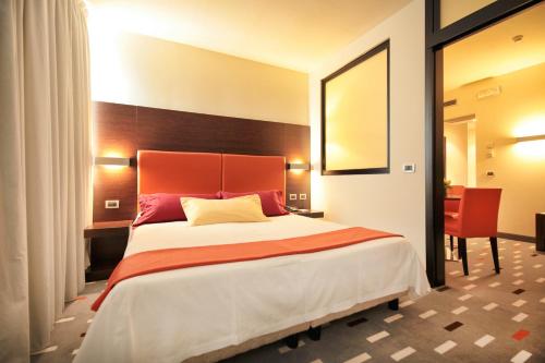 a bedroom with a large bed and a red headboard at Hotel Major in Ronchi dei Legionari