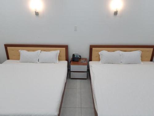 two beds sitting next to each other in a room at Sao Kim in Cà Mau
