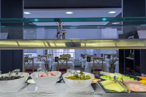 a buffet with bowls of food on a table at Hotel California Palace in Salou