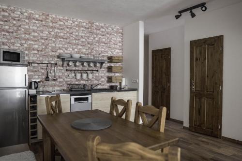 Una cocina con una mesa y sillas de madera en una habitación. en Apartmány Biela Púť - Jasná, en Demänovská Dolina