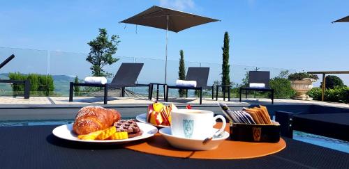 a table with a plate of food and a cup of coffee at La Ribezza Boutique Hotel in Monforte dʼAlba