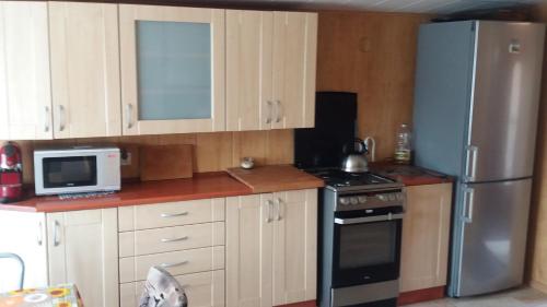 a kitchen with a stainless steel refrigerator and a microwave at Apartament Małgosia in Swarzewo