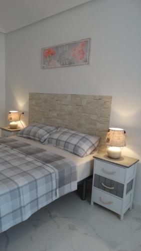 een slaapkamer met een bed en een tafel met een lamp bij Casas Holiday - Playa del Cura 1 in Torrevieja