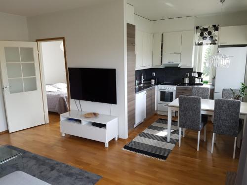 a kitchen and dining room with a table and a television at Adorable Arctic Apartment with sauna in Rovaniemi