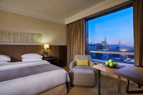 a hotel room with a bed and a large window at Hyatt Regency Belgrade in Belgrade