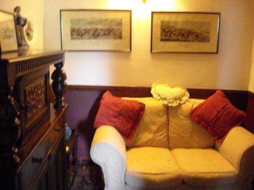 a living room with a couch and a lamp at Townstal Farmhouse in Dartmouth