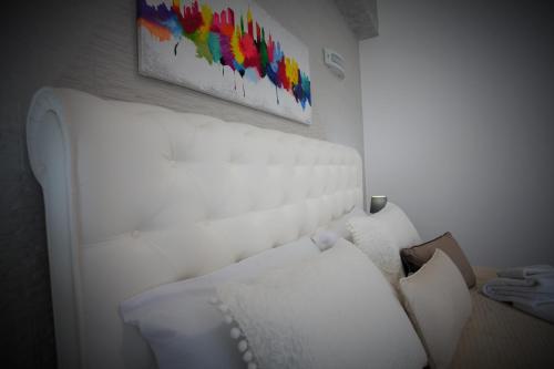 a white couch in a room with a painting on the wall at Central Apartments in Crotone
